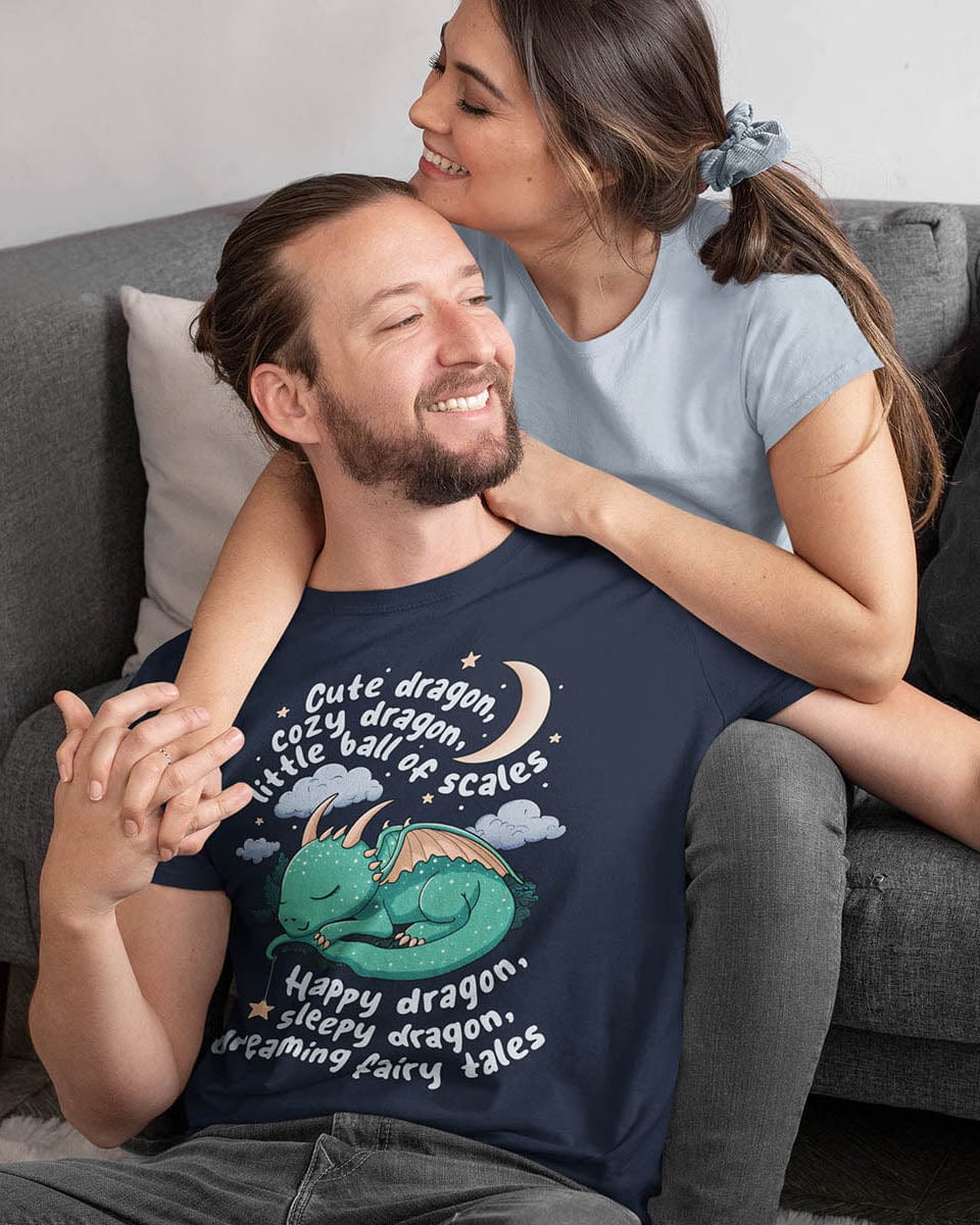 Man cuddling with his girlfriend while wearing a Sleepy Dragon shirt featuring a poem and a dragon curled up under the moon.
