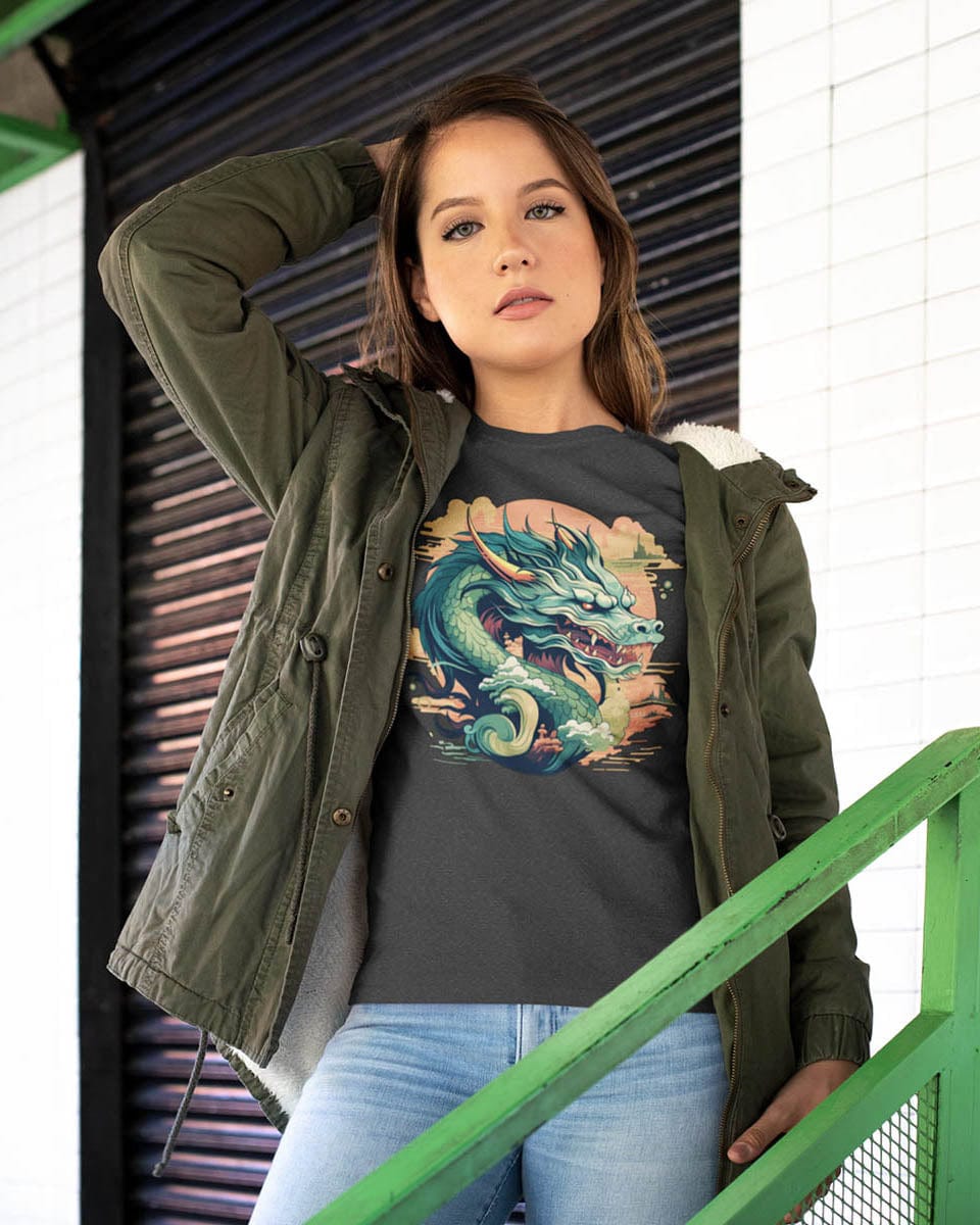 A woman wearing an olive jacket over a Sunset Sovereign Dragon shirt featuring a green serpentine dragon in a sunset sky.