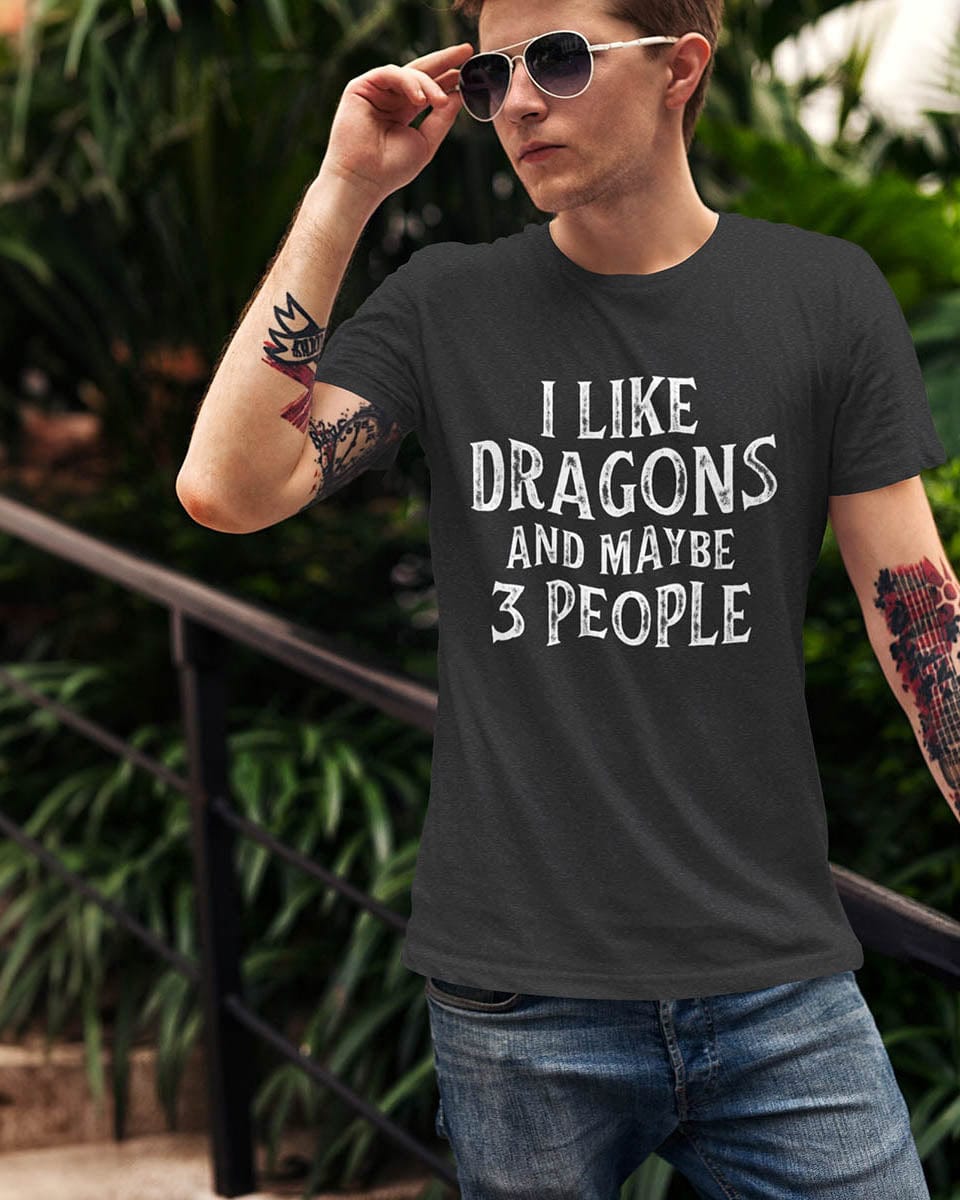 Man wearing an I Like Dragons and Maybe 3 People shirt with a distressed text-only design, standing casually with sunglasses.