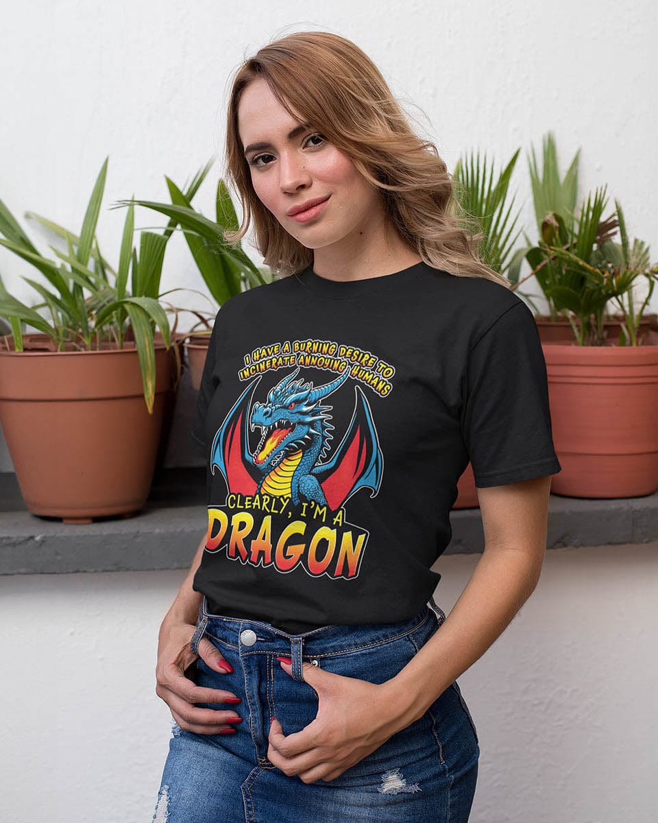 Woman wearing a Dragon shirt that says: I HAVE A BURNING DESIRE TO INCINERATE ANNOYING HUMANS / CLEARLY, I’M A DRAGON”.