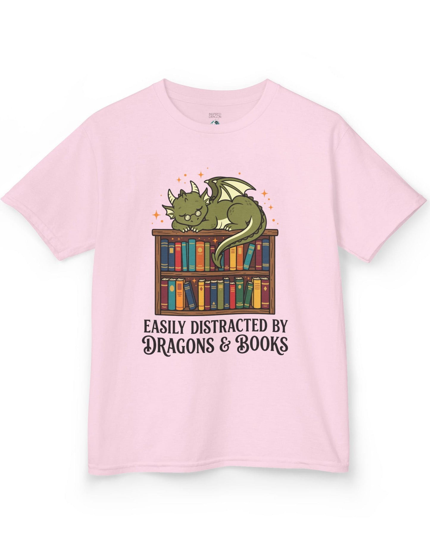 Easily Distracted by Dragons & Books shirt in light pink with a sleepy bookworm dragon lounging on a colorful bookshelf