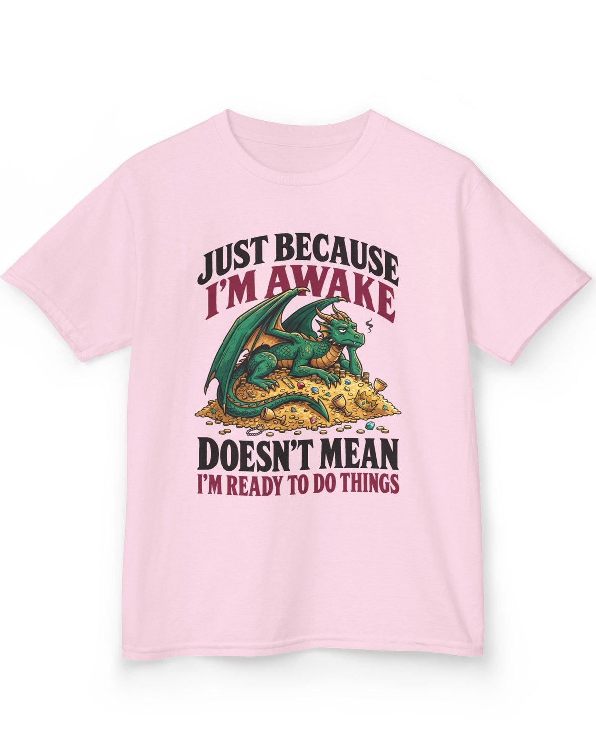 Just Because I'm Awake shirt in light pink featuring a sleepy green dragon lounging on a pile of gold beneath bold text
