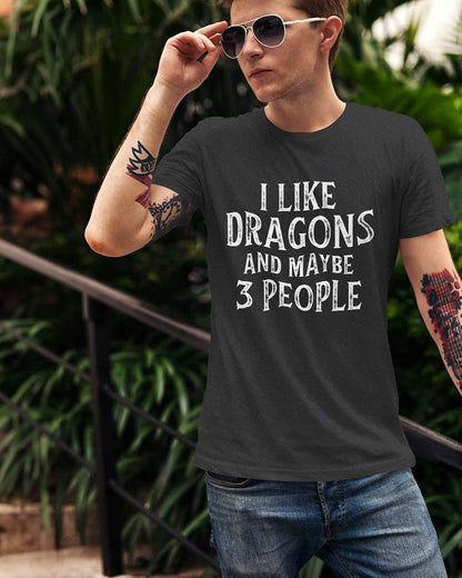 Man wearing an I Like Dragons and Maybe 3 People shirt with a distressed text-only design, standing casually with sunglasses.
