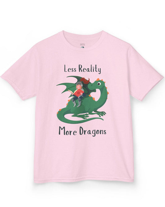 Less Reality, More Dragons shirt in light pink featuring a knight reading a book while riding a friendly green dragon.