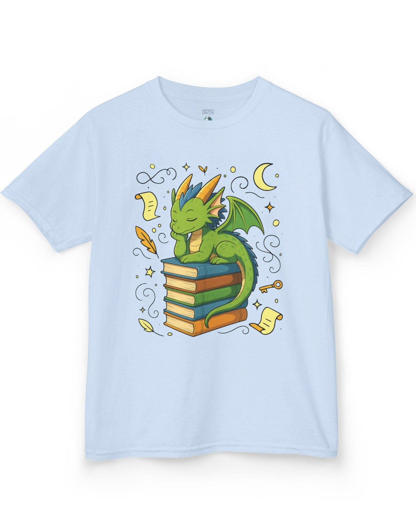 Enchanted Daydreamer shirt in light blue, featuring a sleepy green dragon resting atop a stack of colorful books.