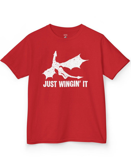 Just Wingin' It shirt in red, featuring a distressed silhouette of a flying dragon above bold text.
