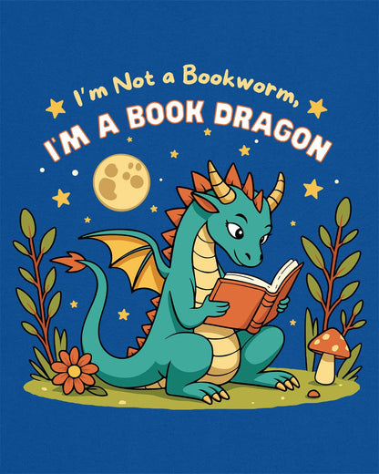 I'm a Book Dragon shirt in royal blue featuring a teal dragon reading under the moonlight with plants and mushrooms.