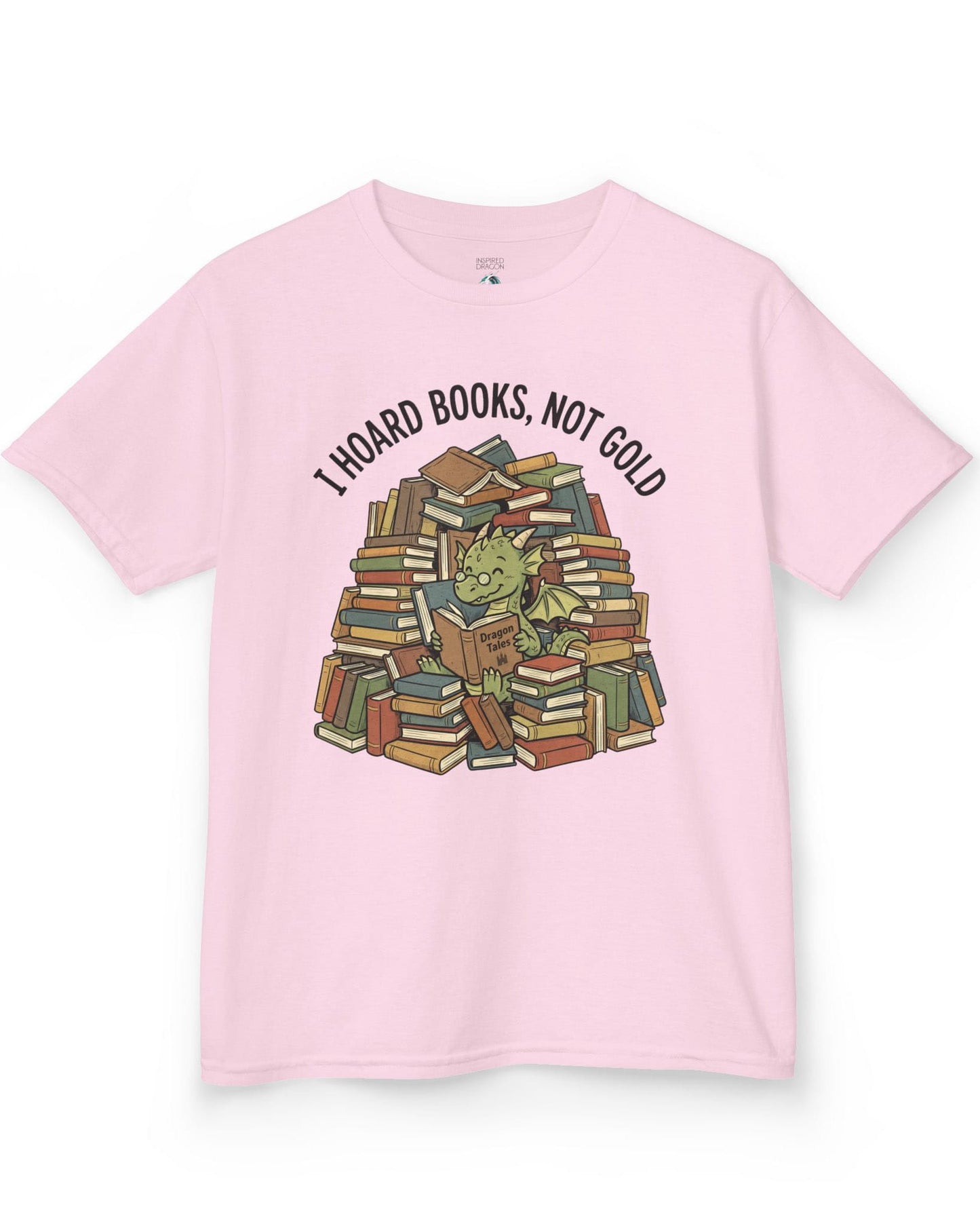 I Hoard Books, Not Gold shirt in light pink featuring a book-loving green dragon nestled in a towering hoard of books