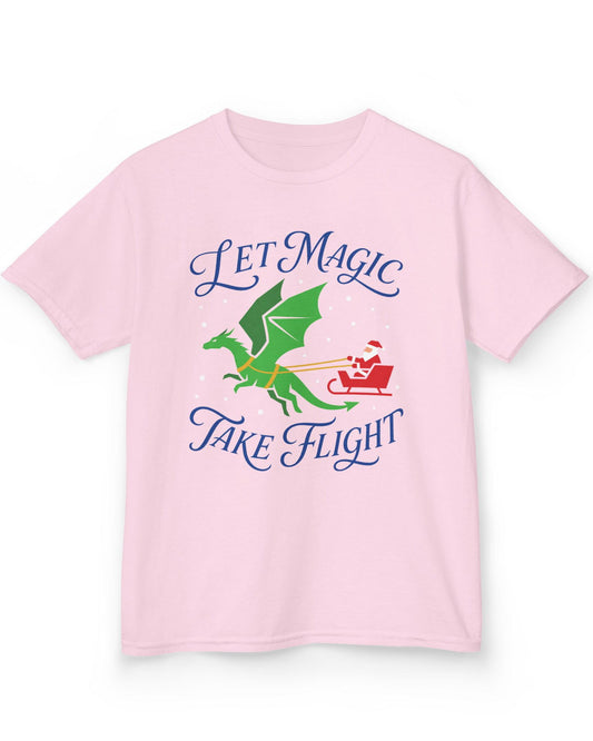 Let Magic Take Flight shirt in light pink featuring a green dragon pulling Santa in a red sleigh through falling snow
