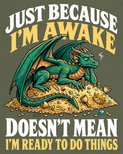Just Because I'm Awake shirt in military green featuring a sleepy green dragon lounging on a pile of gold beneath bold text