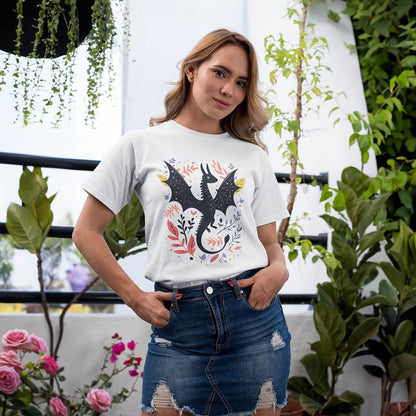 Woman in a garden wearing a Nature Dragon Shirt featuring a whimsical flying dragon surrounded by leafy accents.