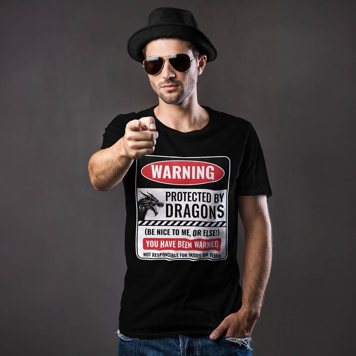 Man pointing at the camera while wearing a Protected by Dragons Shirt featuring a funny warning sign about dragons.